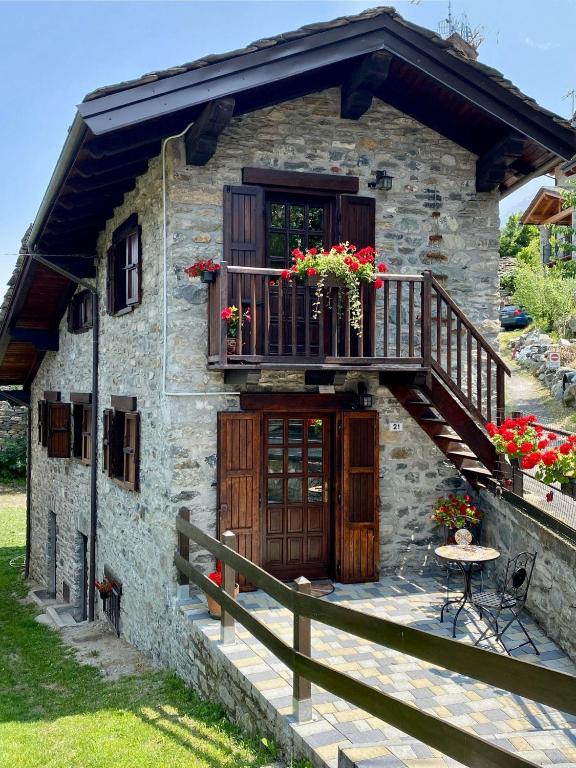 a stone house with a balcony and a porch at Petite Maison Tillier in Fenis