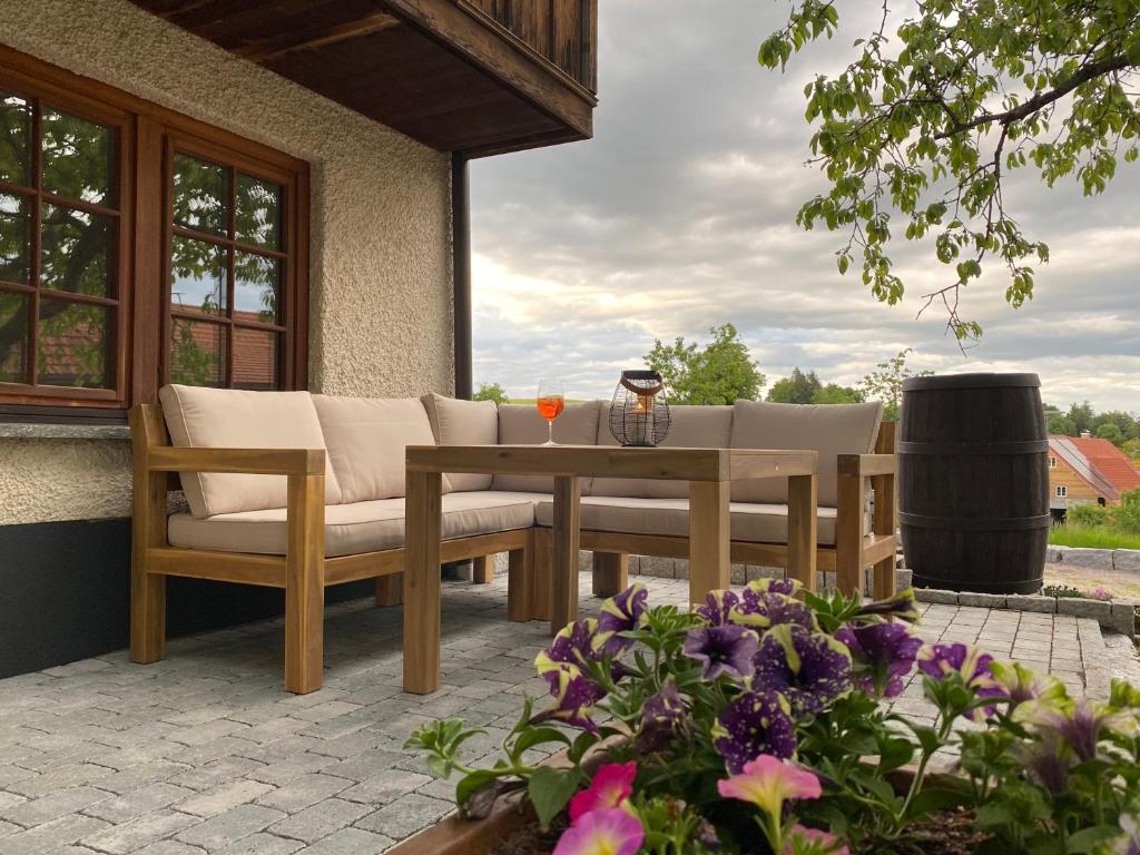 a patio with a table and chairs and flowers at Schwarzwaldnest Dachsberg in Wilfingen