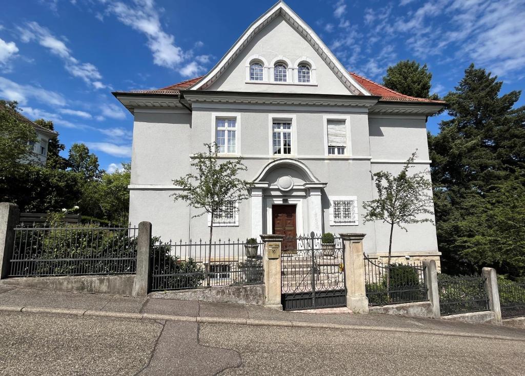 a white house with a fence in front of it at Merkurblick in Baden-Baden