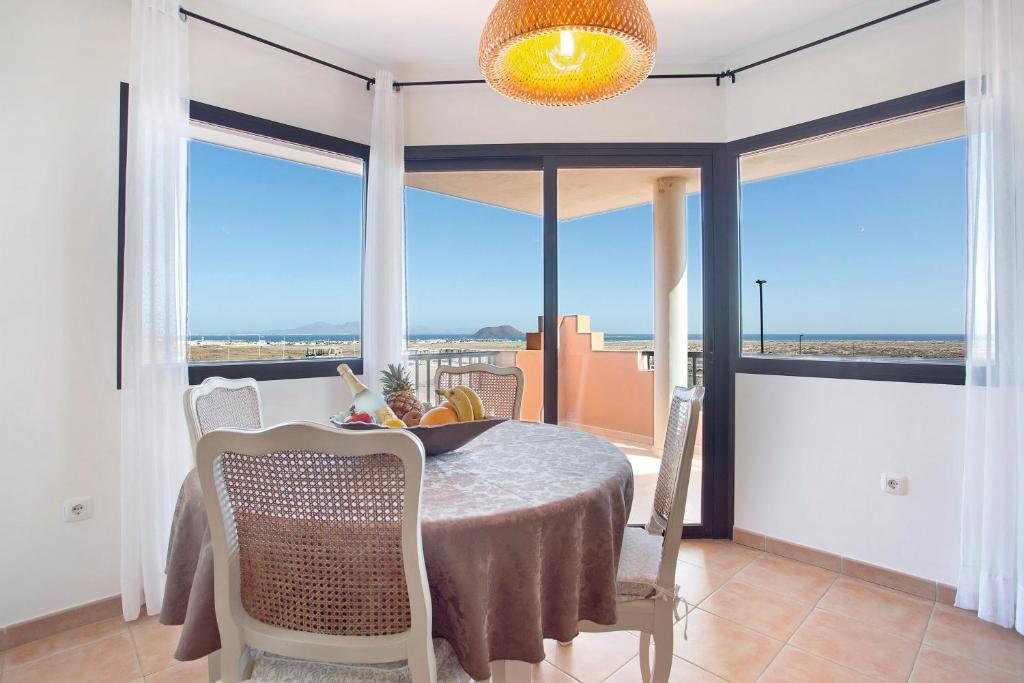 a dining room with a table and views of the city at Vista de Lobos in Corralejo