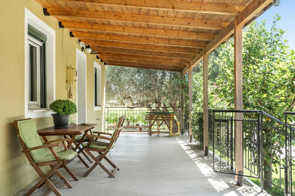 a patio with a wooden pergola and tables and chairs at Ktima Dilberaki in Lixouri
