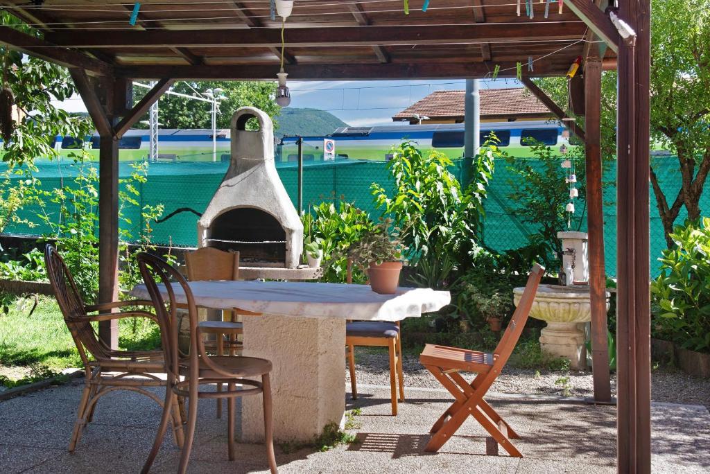a patio with a table and chairs and an outdoor oven at Casa Maria in Porto Ceresio