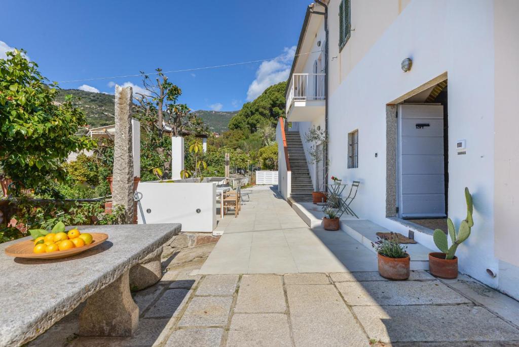 a pathway leading to a house with a bowl of oranges at Casa Magnolia Loft in Seccheto