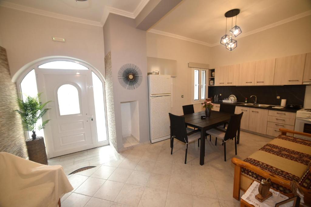 a kitchen and dining room with a table and chairs at Nicol apartment in Koustáros