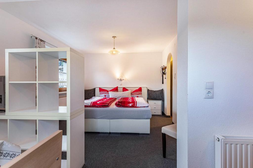 a bedroom with a bed with red pillows at Bergwelt C in Niederau