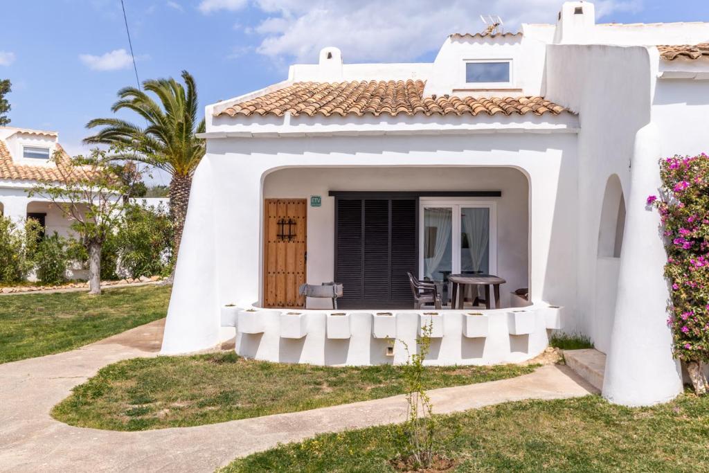 a white house with a porch with a table and chairs at Cala Serena Beach in Felanitx