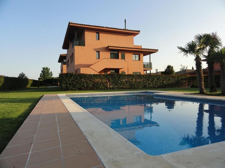 a house and a swimming pool in front of a house at Royal Horizón Dúplex in Navata