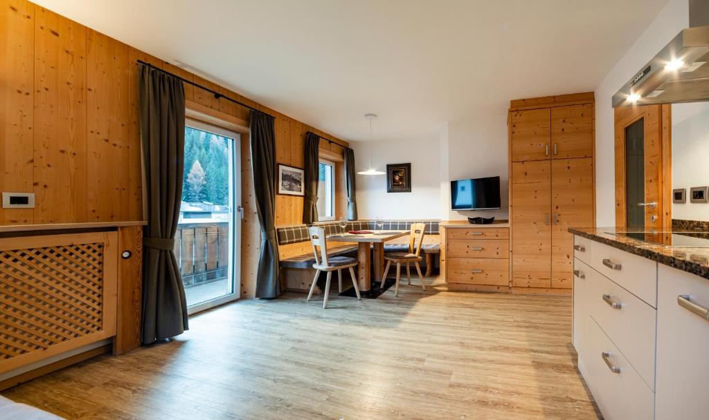 a kitchen with a table and a dining room at Stoffel Apartments Martina in Selva