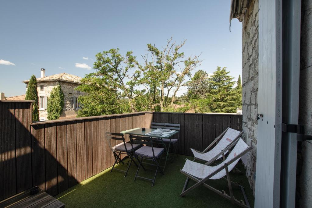 a patio with a table and chairs on a balcony at Viognier - logement avec jacuzzi in Ruoms