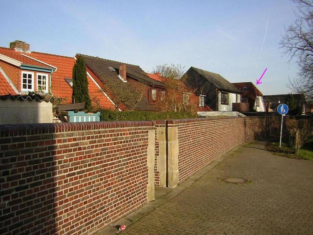 a brick fence in front of some houses at An't Fischerspad in Wangerland