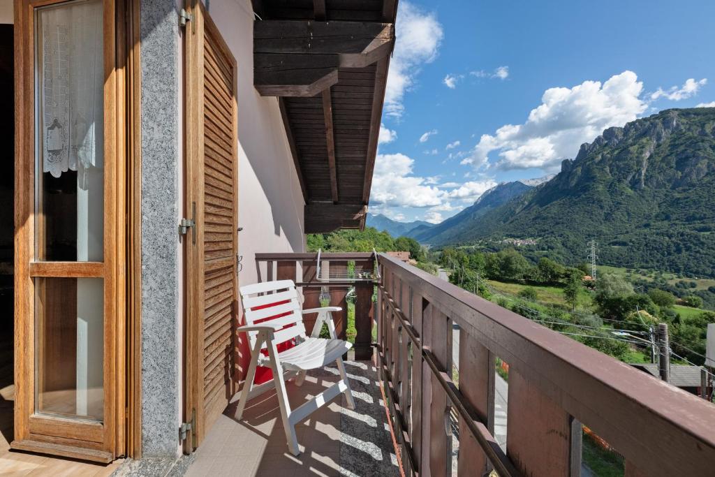 a balcony with two chairs and a view of mountains at Casa Vendrogno in Bellano
