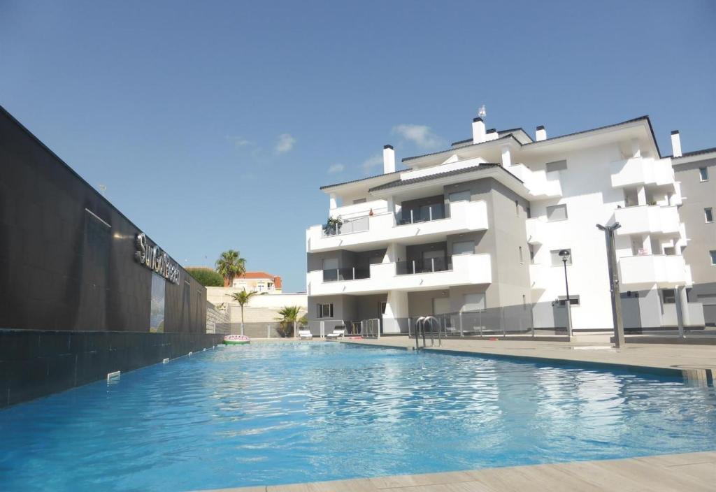 a swimming pool in front of a building at Great apartment with pool - jacuzi in Villacosta