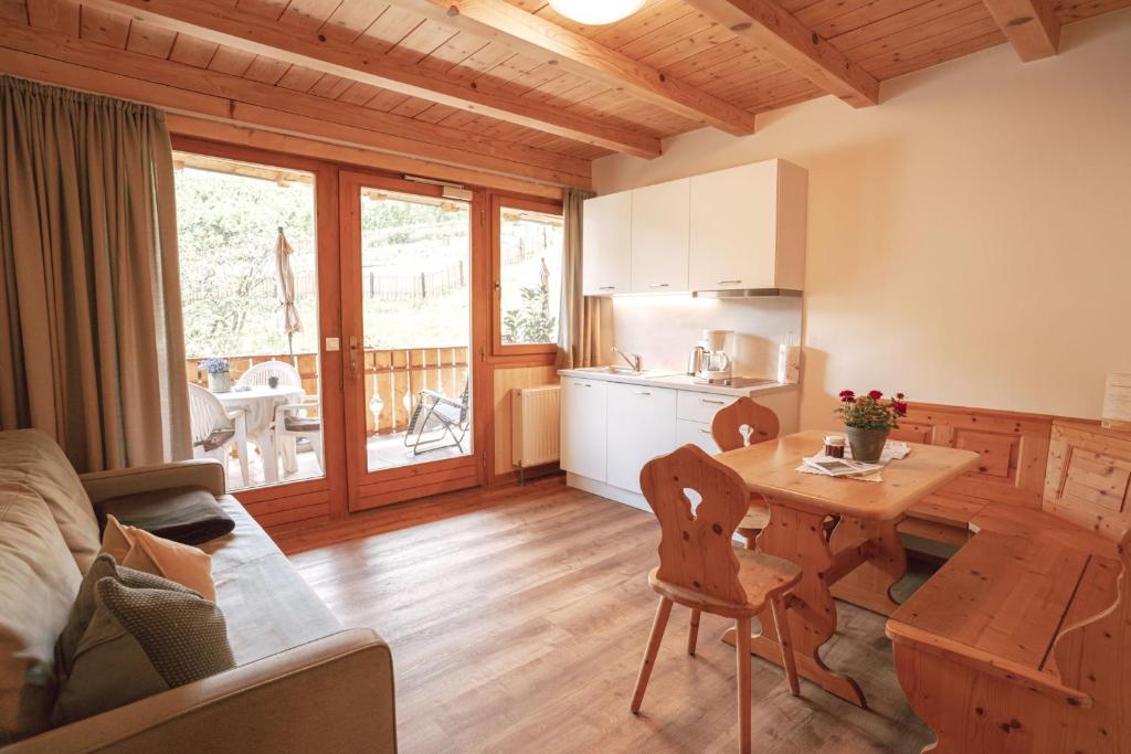 a kitchen and a living room with a table and a dining room at Apartment Toni - Obermösslhof in Lana
