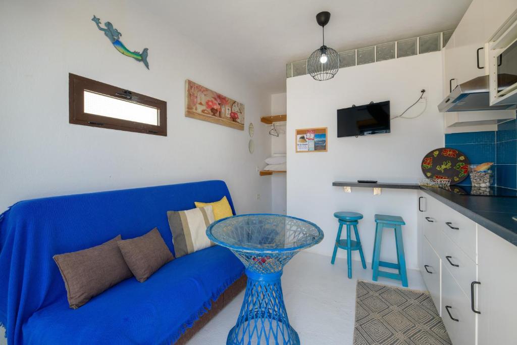 a living room with a blue couch and a counter at Loft La Caletilla La Graciosa in Caleta de Sebo
