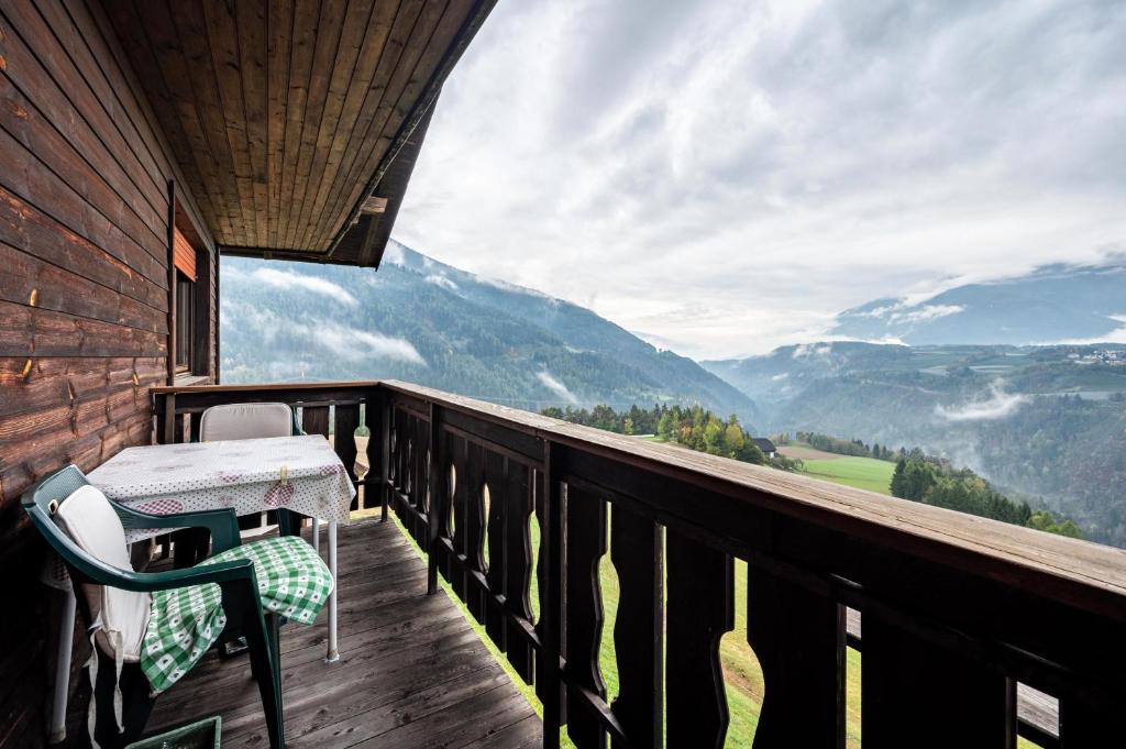 a balcony with a table and a chair on a deck at Ferienwohnung Gatscherhof in Luson