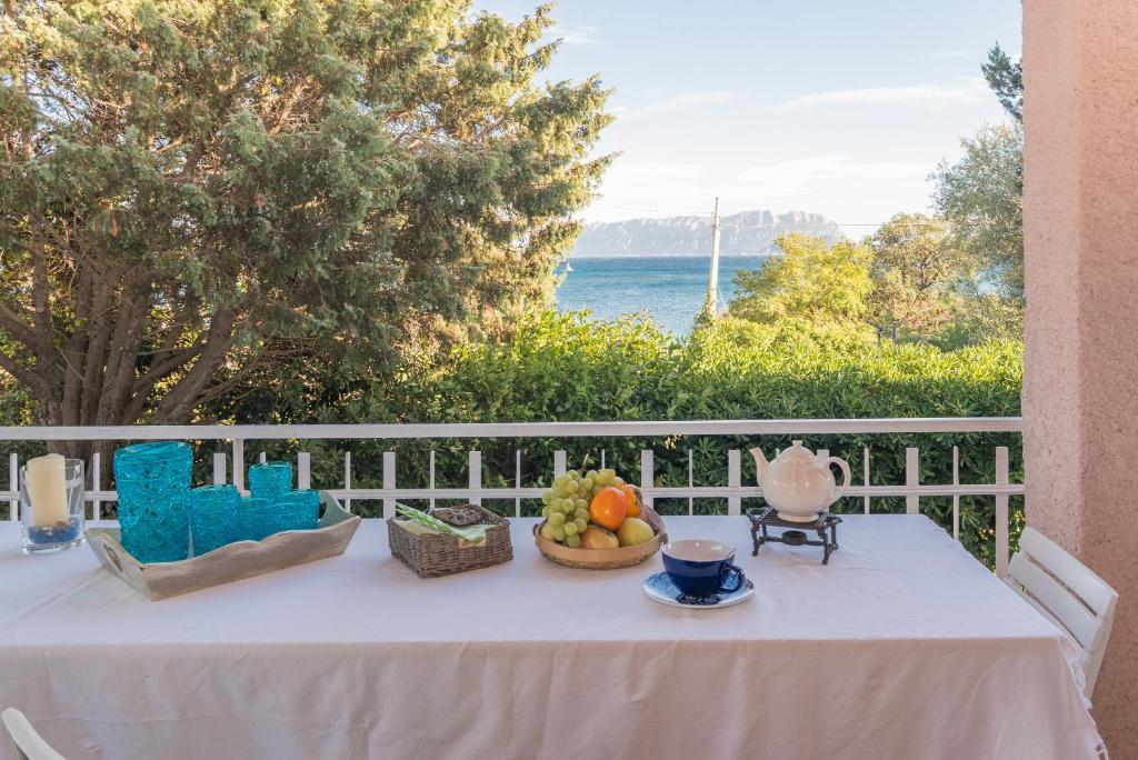 a table with a bowl of fruit on a balcony at Villa Rosa sul mare in Olbia