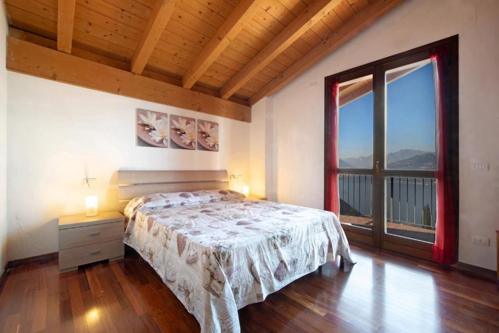 a bedroom with a bed and a large window at Magic moment in Lake Como in Perledo