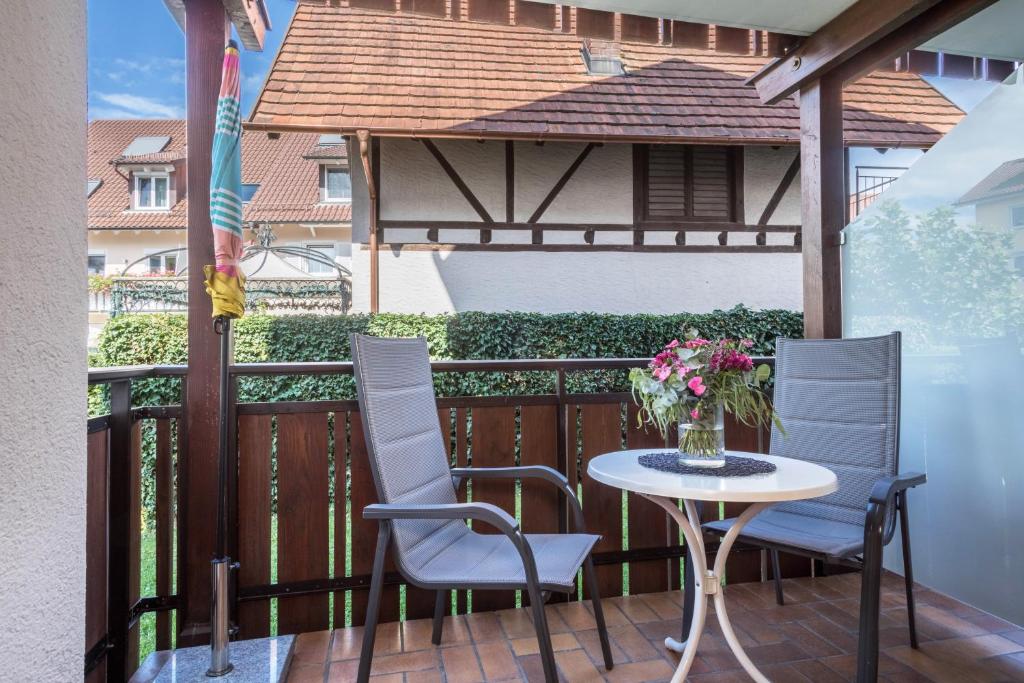 a table and chairs on a balcony with a gazebo at Gästehaus Heinemann - Eg3 in Langenargen