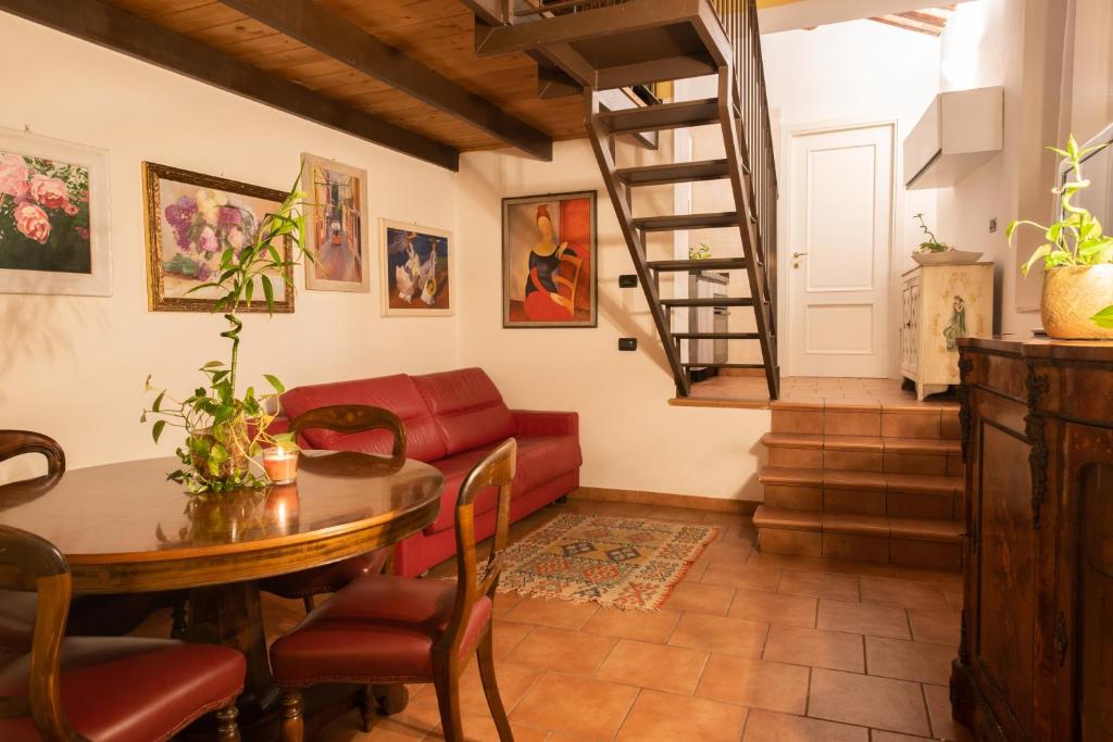 a living room with a table and a red couch at Romantica Corte Degli Estensi in Ferrara