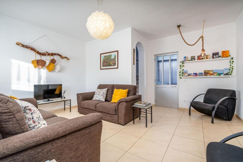 a living room with two couches and a tv at Casa Quintião in Ferragudo