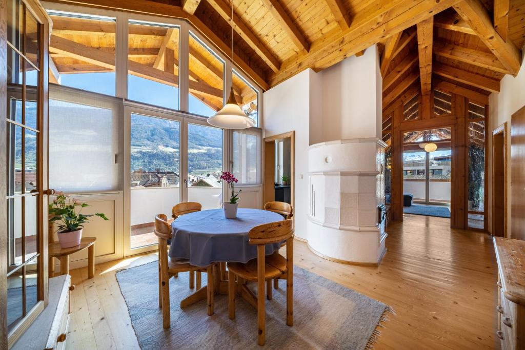 a dining room with a table and chairs and windows at Apartment Luisa in Silandro