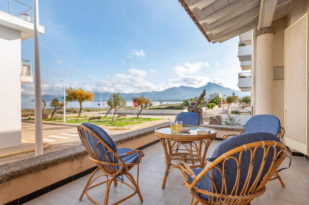 a balcony with chairs and a table and a view of the water at Cas Cover in Santa Margalida
