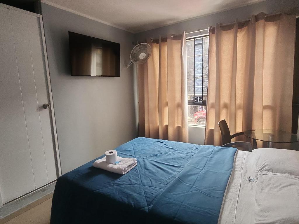 a bedroom with a blue bed with a towel on it at Hospedaje costa pacífico in Chimbote