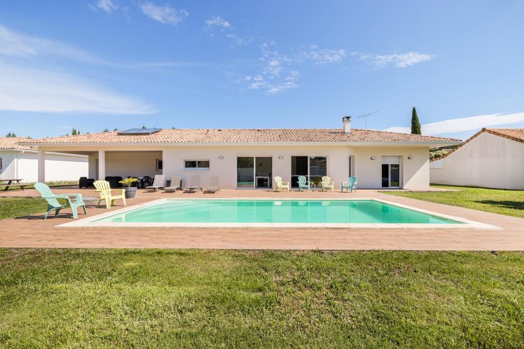a swimming pool in front of a house at Villa Lumière Ychoux in Ychoux