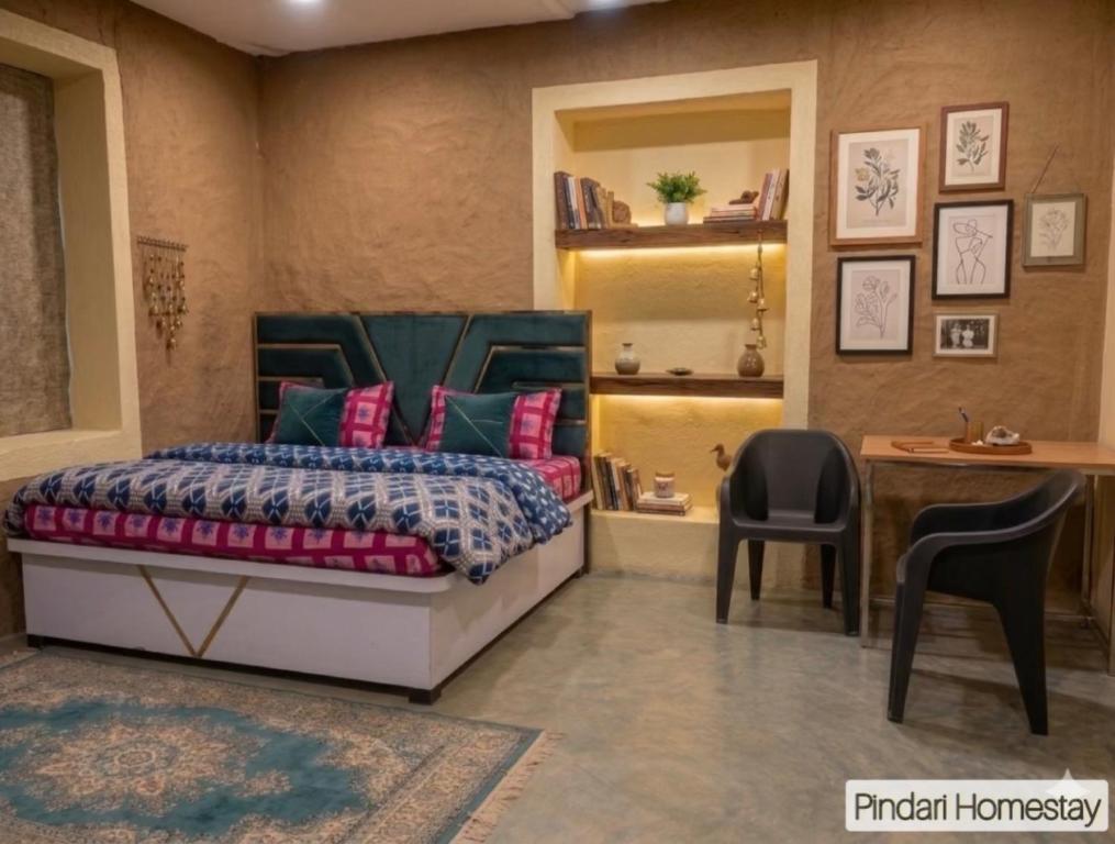 a bedroom with a bed and a desk and a chair at Pindari Homestay in Bāgeshwar