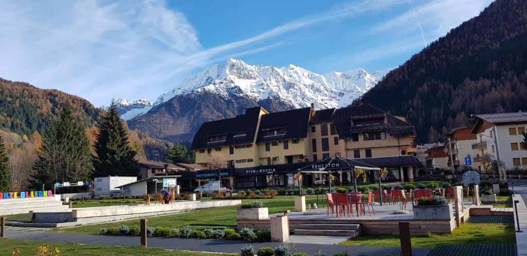 a large building with a mountain in the background at Luminoso appartamento centrale in Ponte di Legno