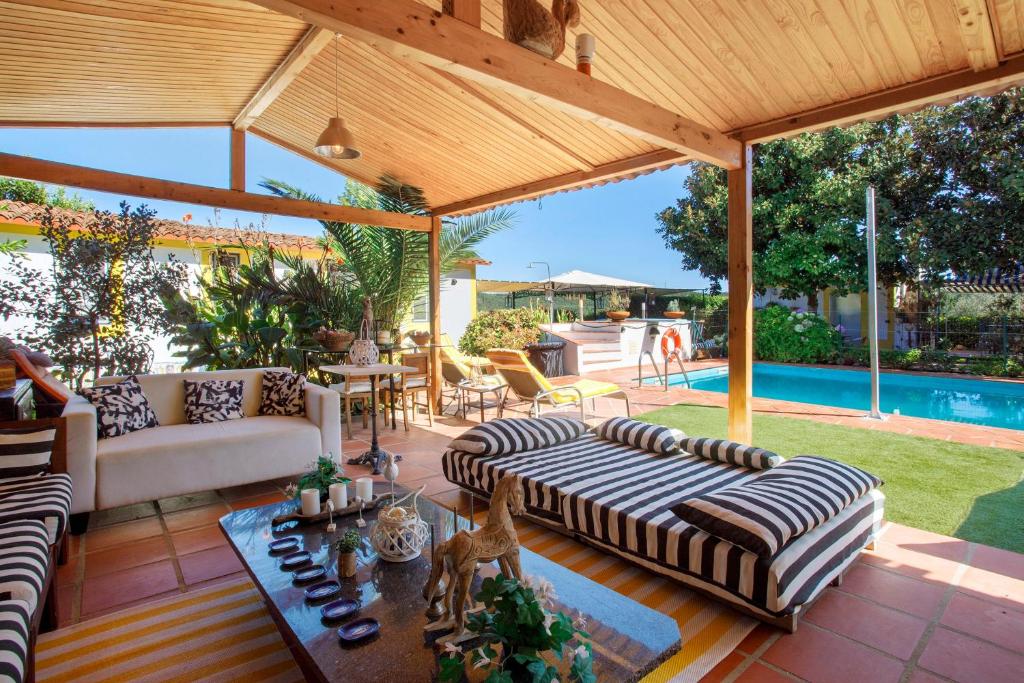 a covered patio with couches and a pool at Casa do Campo Dornes Três in Paio Mendes