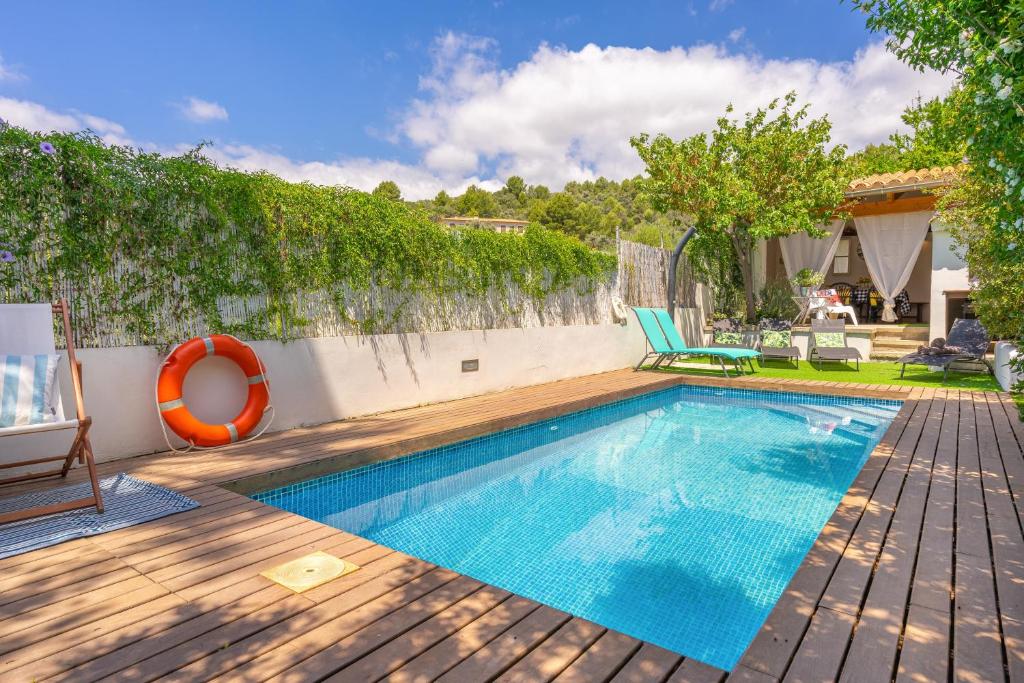 a swimming pool in a backyard with a wooden deck at Es Clos in El Port de la Selva