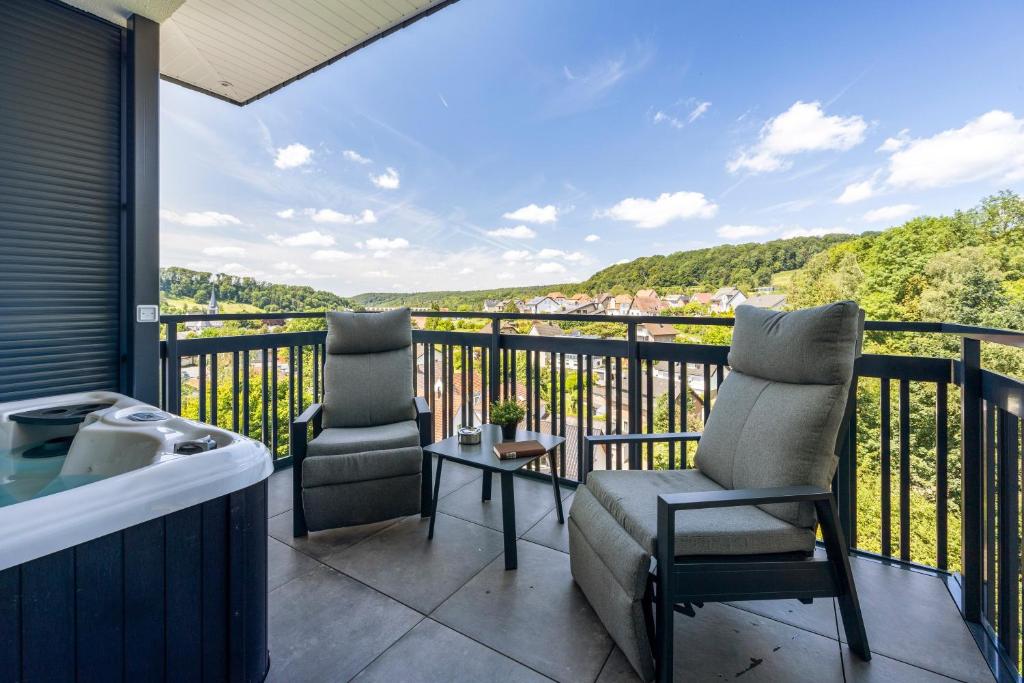 a balcony with two chairs and a table and a view at Egge Resort 7b mit Whirpool u Sauna in Altenbeken