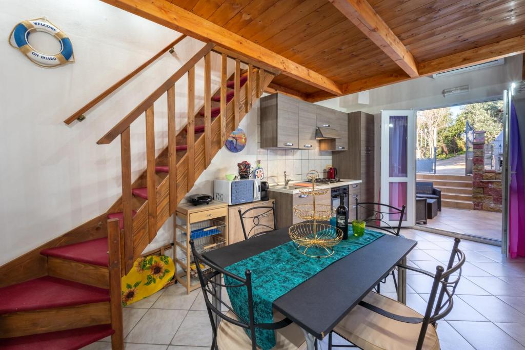 a kitchen with a dining table and a staircase at Casa Ornella in Nebida