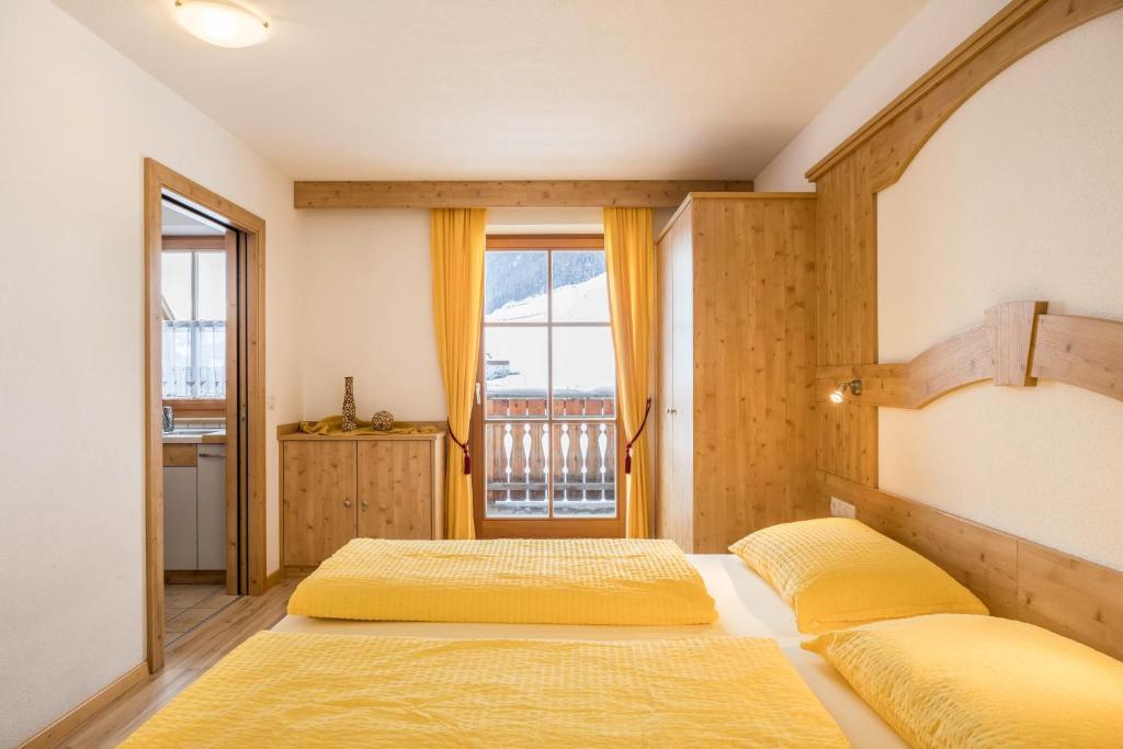 a bedroom with two beds and a window at Wollbach - Gruberhof in San Giacomo