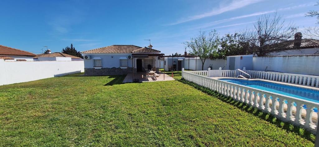 a backyard with a swimming pool and a fence at Chalet Tu Limonero in Chiclana de la Frontera