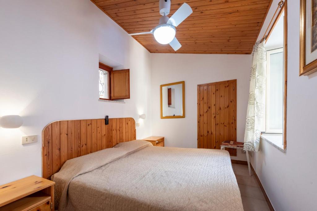 a bedroom with a bed and a wooden ceiling at La Casetta Della Rocca Cefalù in Cefalù
