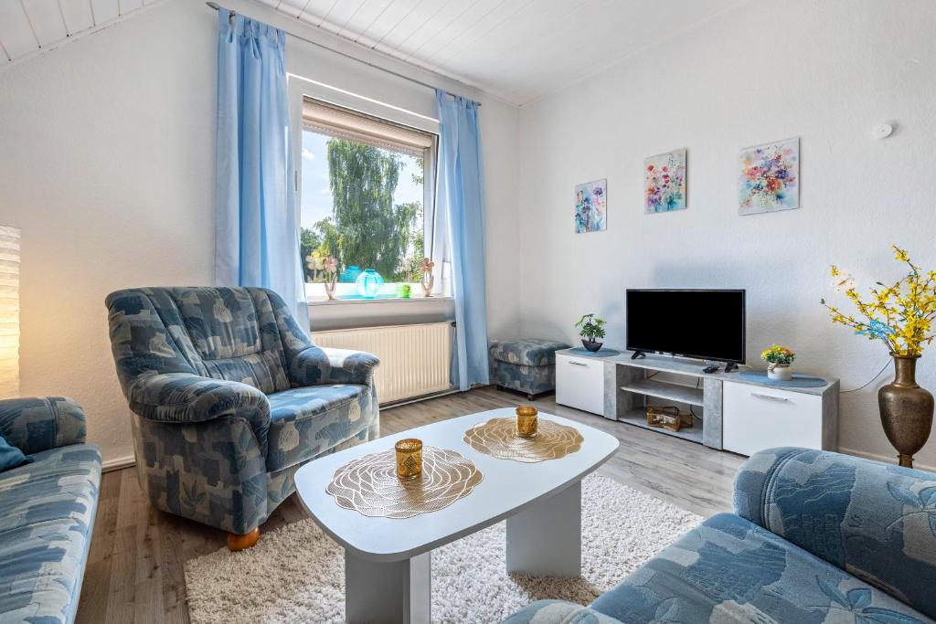 a living room with two chairs and a tv at Haus Elseaue in Bünde