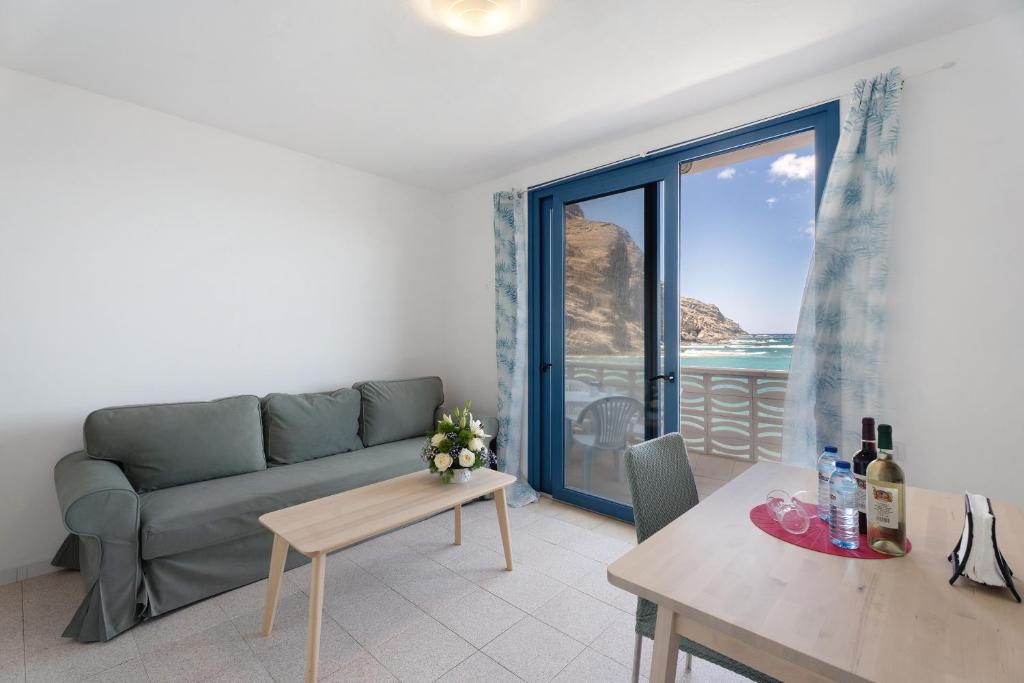a living room with a couch and a view of the ocean at Apartamentos Playa Azul - 9 in Vallehermoso