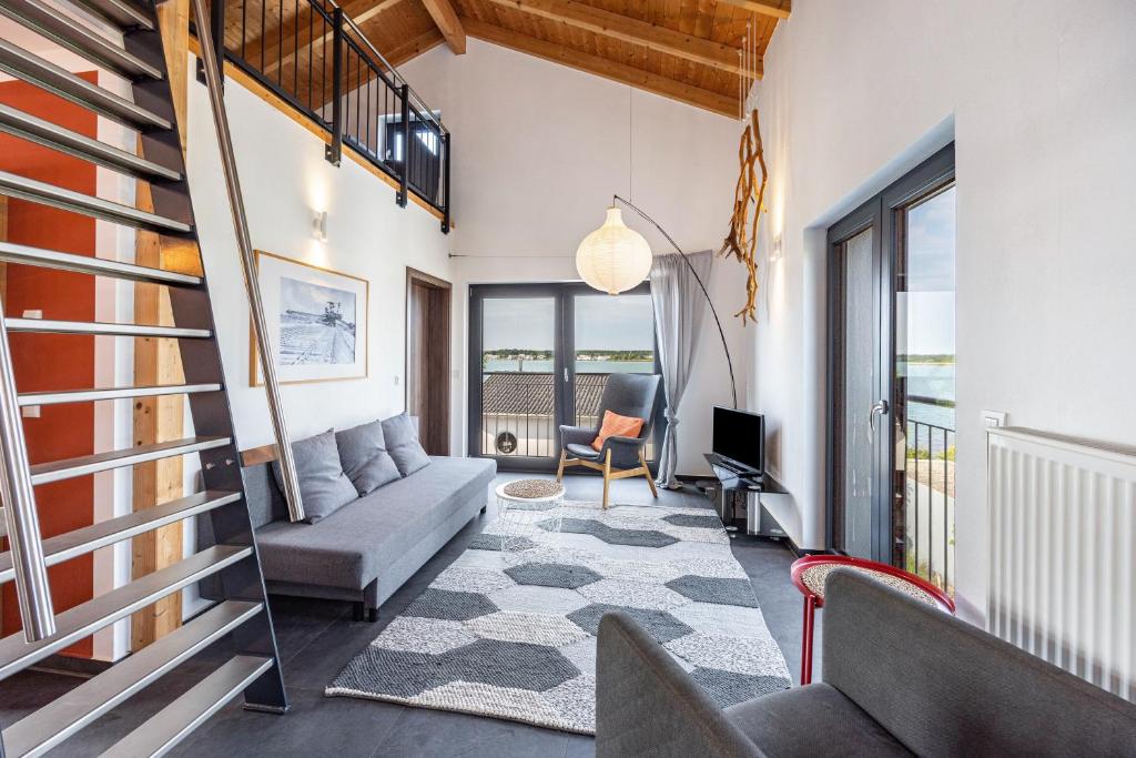 a living room with a couch and a chair at Ferienhaus Sonnenwind Hainer See Og in Neukieritzsch