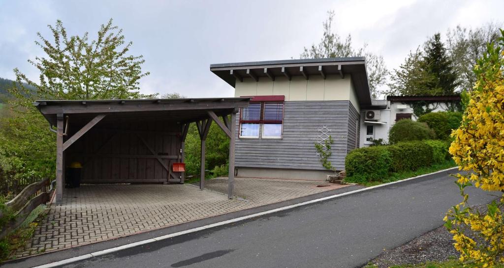 a house with a garage next to a road at Fewo Heym in Suhl