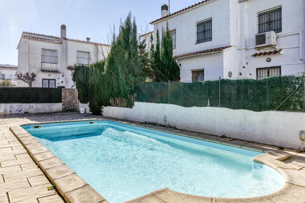 a swimming pool in front of a building at Villa La Flor con piscina in L'Escala