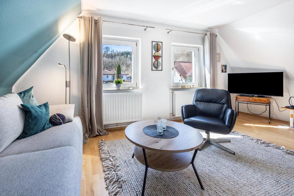 a living room with a couch and a chair and a table at Waldgästehaus Externsteine in Horn-Bad Meinberg