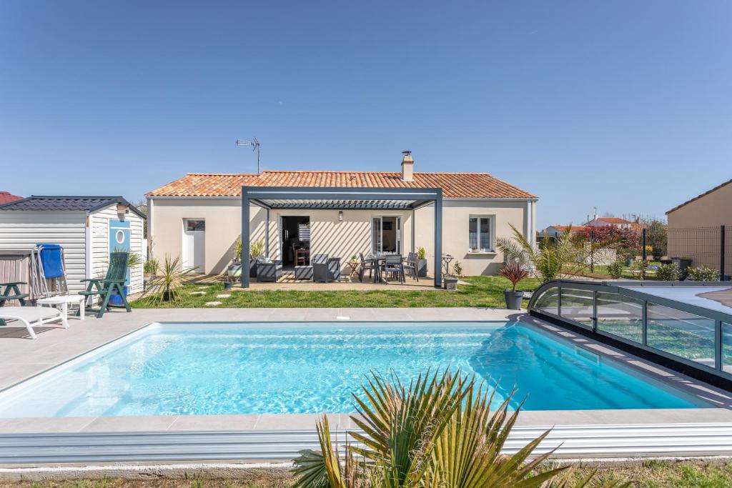 a swimming pool in front of a house at Maison Salorge - piscine privée in Jard-sur-Mer