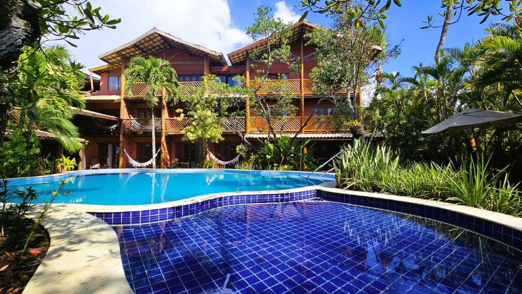a resort with a swimming pool in front of a building at Pousada Casa do Forte in Praia do Forte