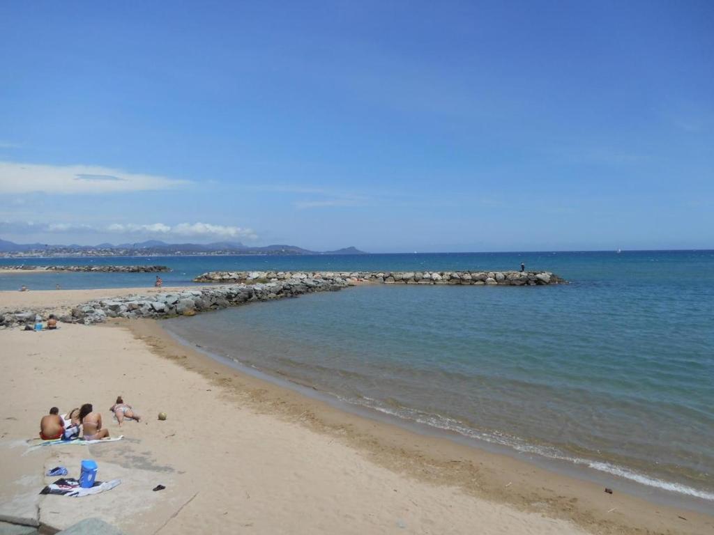 a group of people sitting on the beach at Duplex Appartement 300m de la mer in Fréjus