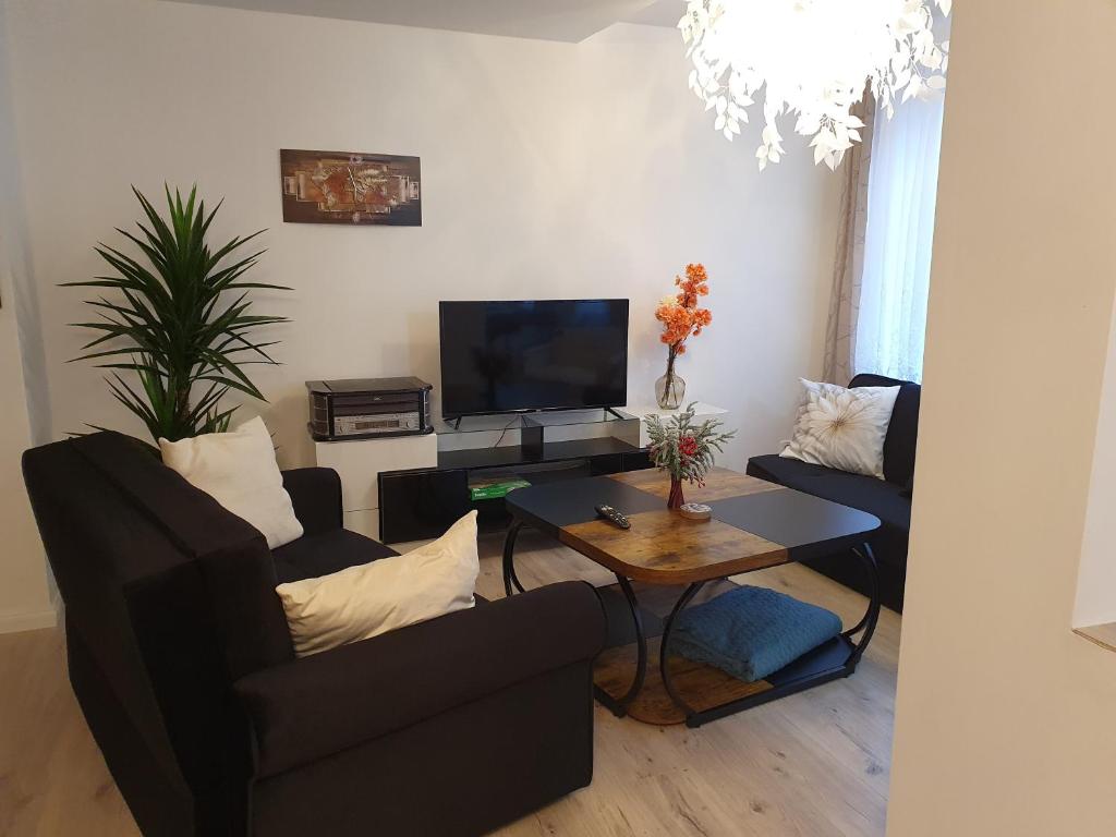 a living room with two couches and a table at Hochwertige Ferienwohnung in Lübeck