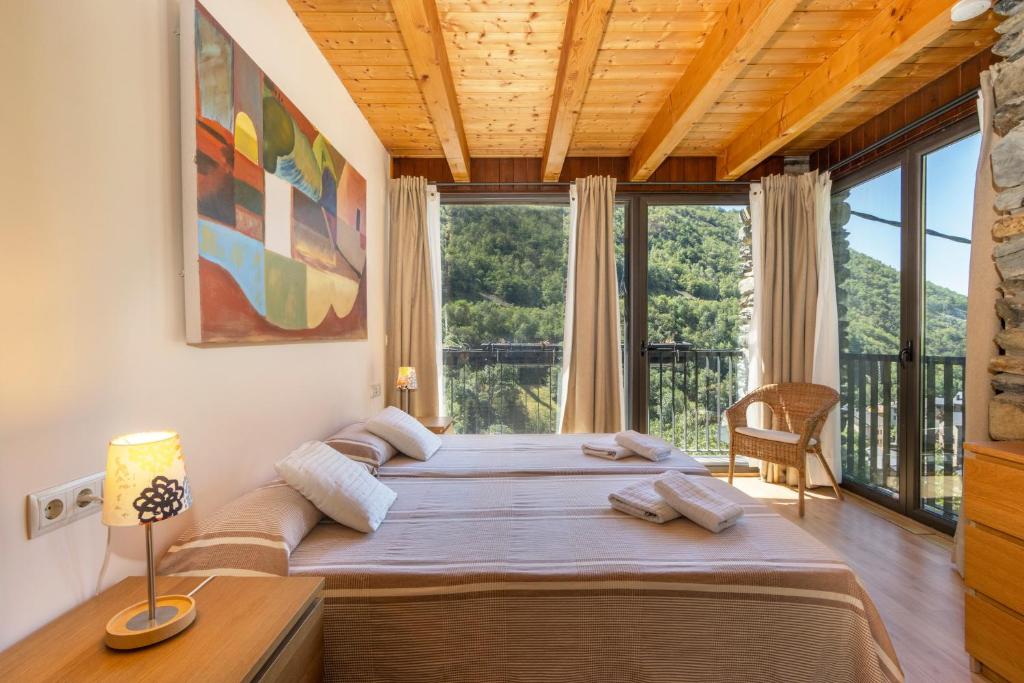 a bedroom with a large bed and large windows at Casa Guillem 2 in Tavascan