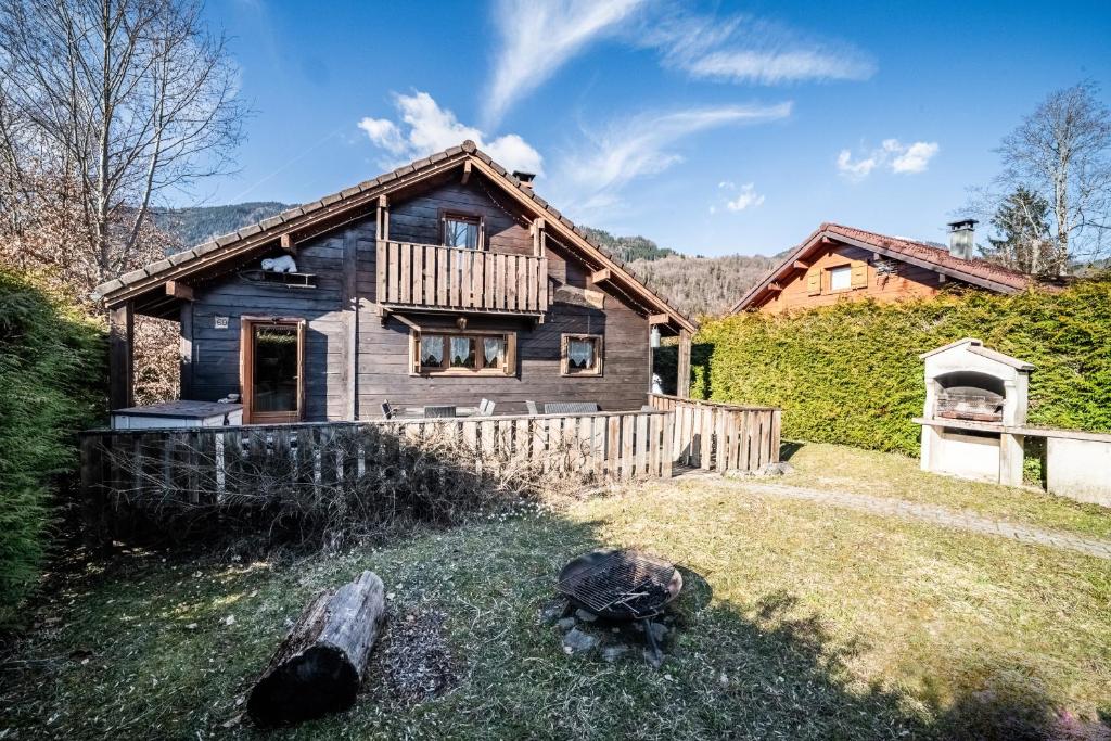 a log cabin with a porch and a house at Chalet 6p Classique - L'ourson in Verchaix