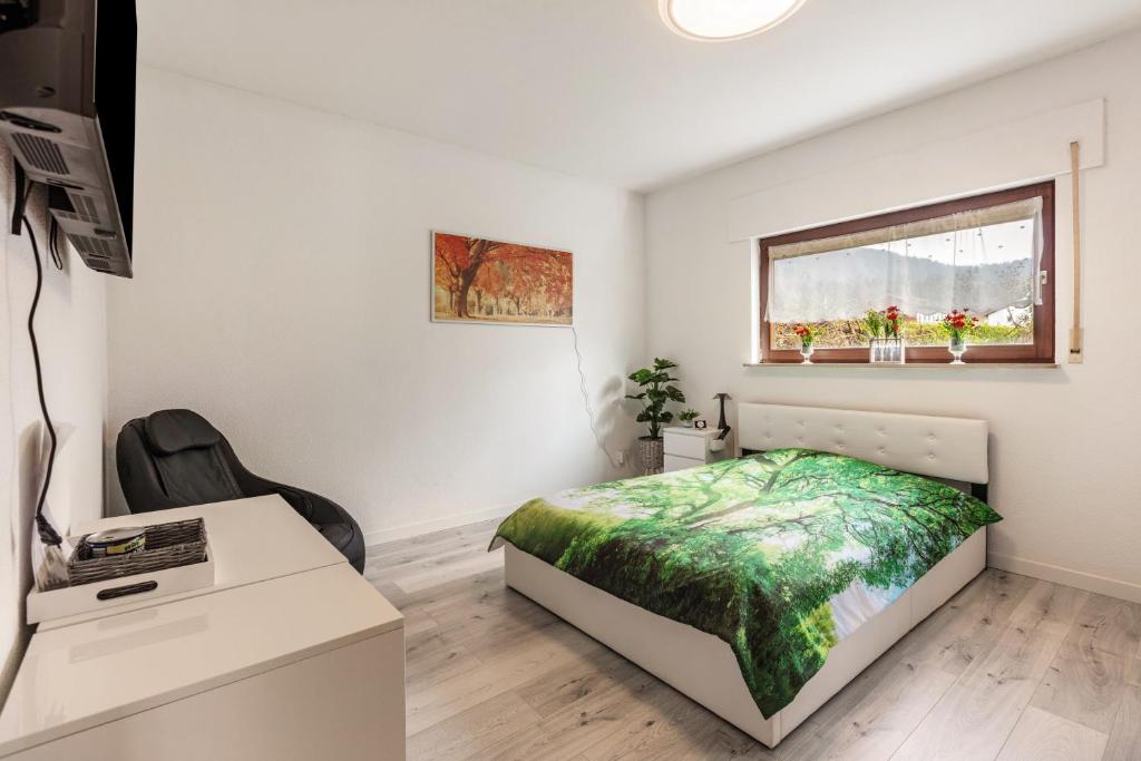 a bedroom with a bed and a desk and a window at Haus Sonnenschein Bad Säckingen in Bad Säckingen